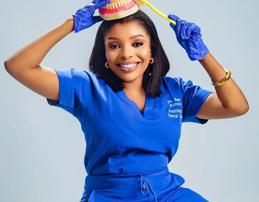 Member of the Royal Aesthetics Dental Clinic team holding a denture model